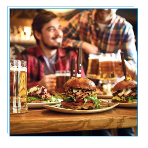 Dos hombres sentados en un bar con comiida y cerveza